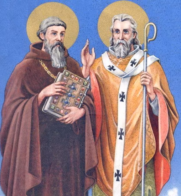 Illustration of Saints Cyril and Methodius (Cyril a Metoděj), depicted with halos. Cyril holds a decorated book symbolizing literacy and the Glagolitic alphabet, while Methodius holds a bishop’s staff and raises his hand in blessing.