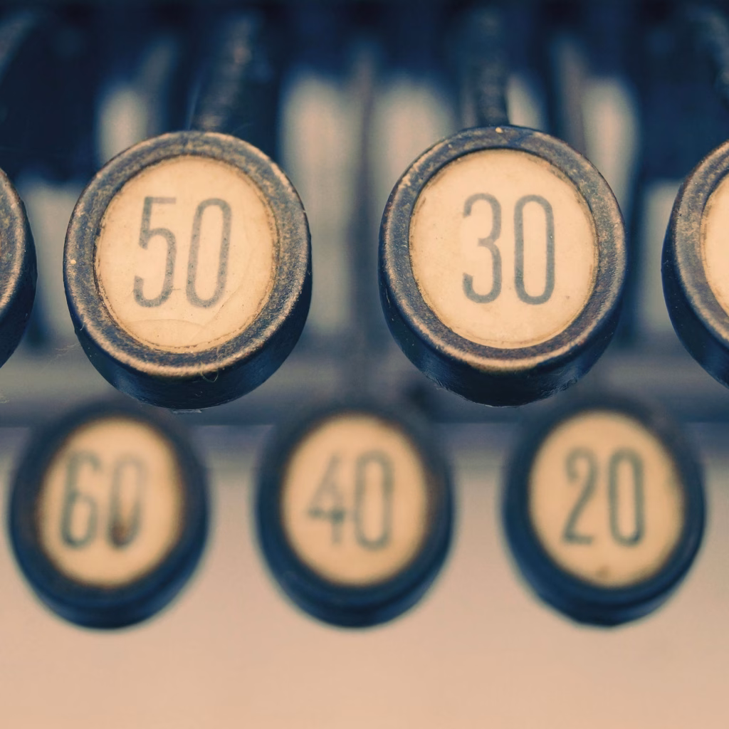 Close-up of a vintage typewriter showcasing numbered keys with a retro feel. Learn how to tell your age in Czech.